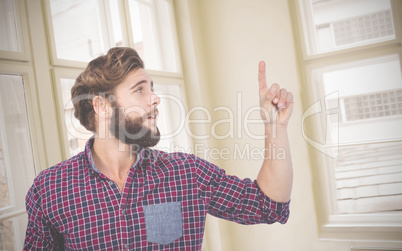 Composite image of hipster pointing upwards