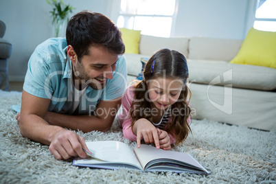 Father and daughter reading book in the living room