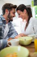 Romantic couple looking face to face while having breakfast