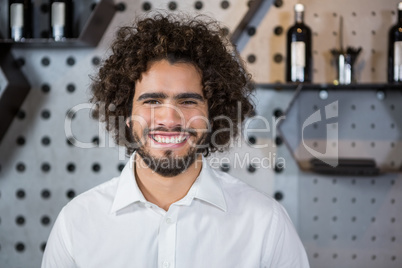 Smiling bartender standing in bar counter