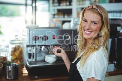 Portrait of smiling waitress making cup of coffee