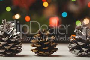 Three pine cones on wooden table