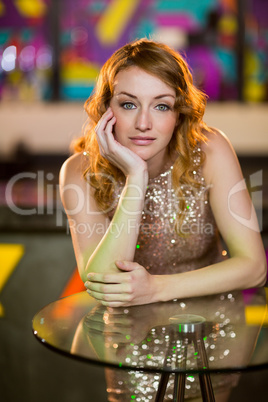 Portrait of young woman leaning on table