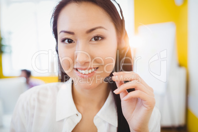 Portrait of happy operator with headphones at creative office