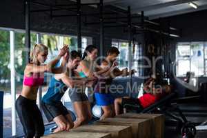 People leaning on wooden cubes in gym