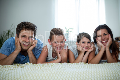 Portrait of parents and kids lying in bedroom