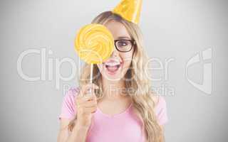 Composite image of portrait of a hipster hiding herself behind a lollipop