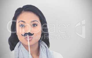 Composite image of pretty asian woman with fake mustache posing for camera