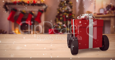 Composite image of red gift box on wheels