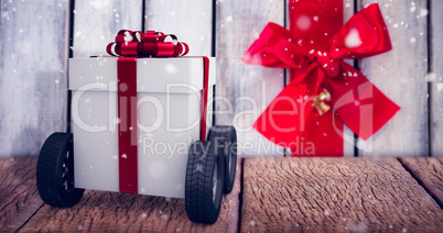 Composite image of gray gift box with wheels