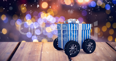 Composite image of digitally generated image of gift box with wheels