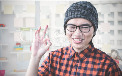 Composite image of smiling hipster making ok sign