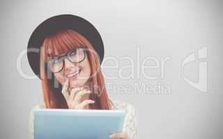 Composite image of smiling hipster woman using her tablet