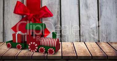 Composite image of miniature train with gift