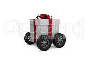 Gift box with red ribbon on wheels