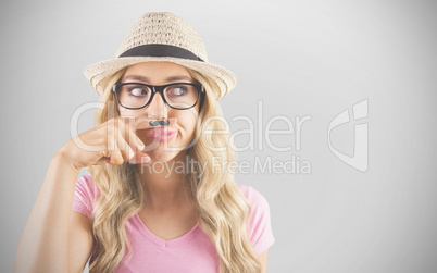 Composite image of a beautiful hipster having a fake mustache