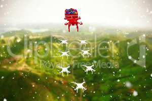 Composite image of high angle view of mini drone pulling chirstmas sledge with gift