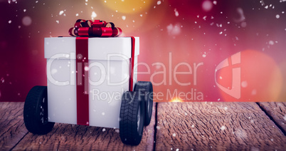 Composite image of gray gift box with wheels