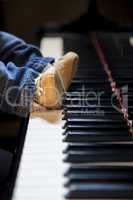 newborn kid feet trying to play piano