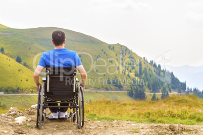 Young man in a wheelchair enjoying fresh air on a sunny day