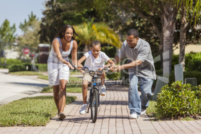 African American Family WIth Boy Riding Bike & Happy Parents