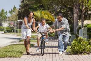 African American Family WIth Boy Riding Bike & Happy Parents