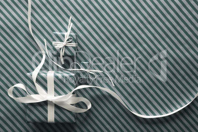 Two Gifts With White Ribbon On Light Green Wrapping Paper