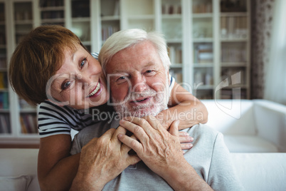 Senior woman embracing man at home