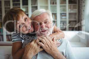 Senior woman embracing man at home