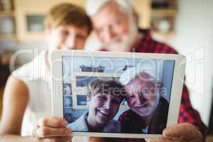 Senior couple clicking a picture on digital tablet