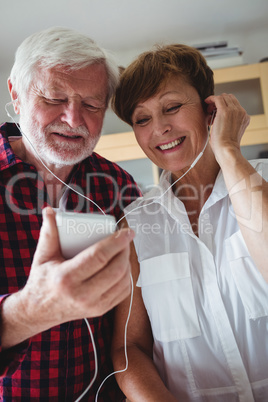 Senior couple listening to music on smartphone