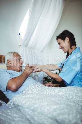 Nurse giving a glass of water to senior man