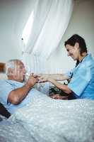 Nurse giving a glass of water to senior man