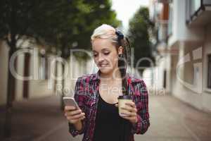 Woman using mobile phone while having coffee