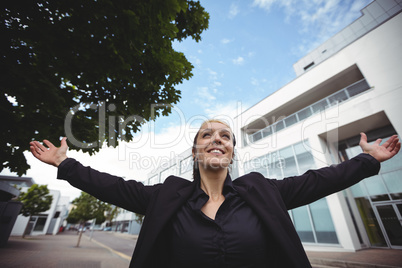 Businesswoman standing with arms outstretched