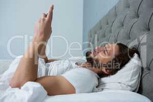 Man using mobile phone in bedroom