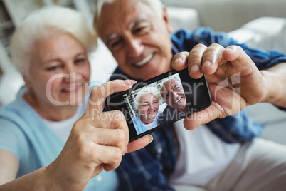 Senior couple taking a photo from mobile phone