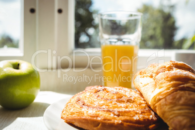 Close-up of croissant and glass of juice