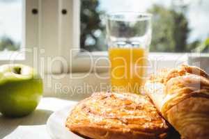 Close-up of croissant and glass of juice