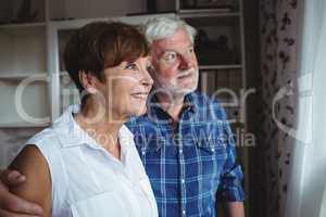 Senior couple looking through window