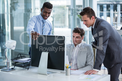 Businesspeople discussing at table over computer