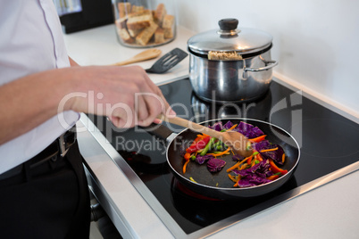 Mid-section of a man preparing food in kitchen