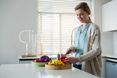 Woman cutting vegetables in kitchen