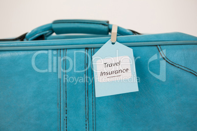 Travel insurance label tied to a suitcase