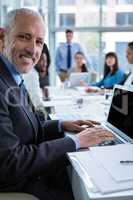 Portrait of businessman working on laptop