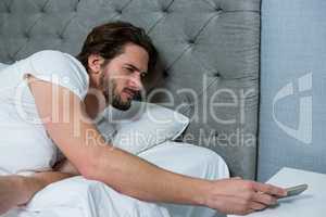Man waking up with mobile alarm clock