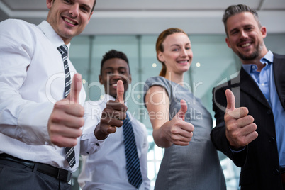 Business executive showing thumbs up in office