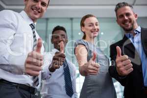 Business executive showing thumbs up in office