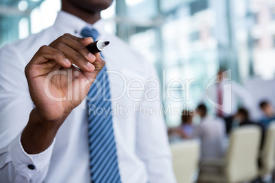 Businessman writing with marker on glass