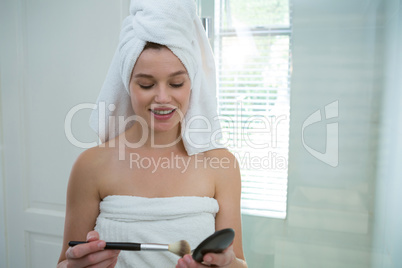 Woman holding make-up in bathroom